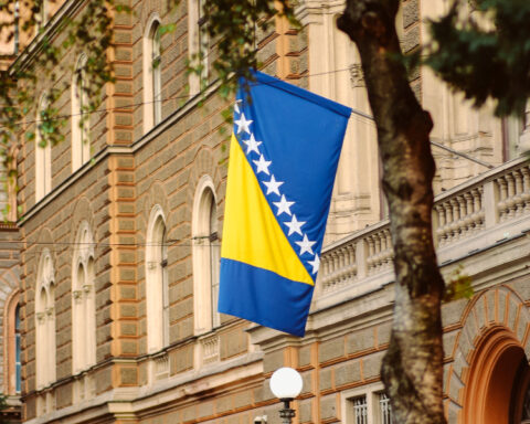 Bosnia and Herzegovina flag displayed on a building, illustrating the Republika Srpska lobbying dispute.
