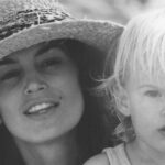 Black-and-white childhood photograph of Presley Gerber with his mother, supermodel Cindy Crawford, wearing a straw hat.
