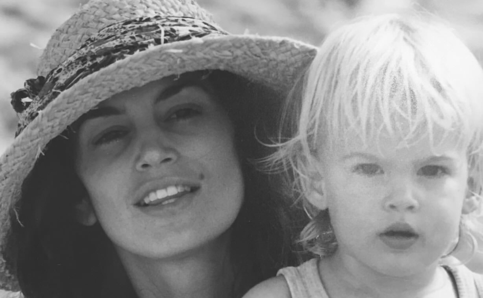 Black-and-white childhood photograph of Presley Gerber with his mother, supermodel Cindy Crawford, wearing a straw hat.