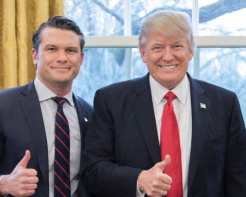 U.S. Defense Secretary Pete Hegseth and President Donald Trump posing together and giving thumbs-up gestures.