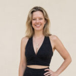 Portrait of Dr Hannah Cain wearing a black outfit and pearl necklace.