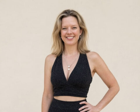 Portrait of Dr Hannah Cain wearing a black outfit and pearl necklace.