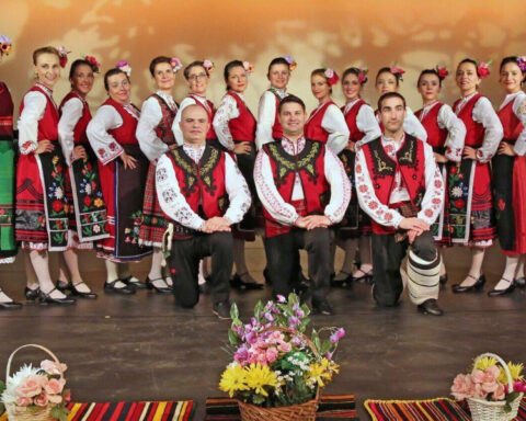 Gorana Dance ensemble members posing on stage in colorful traditional Bulgarian folk costumes.