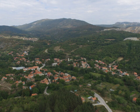 Panoramic view of Krivelj village near Bor, Serbia, with houses, surrounding hills and mining areas in the distance.