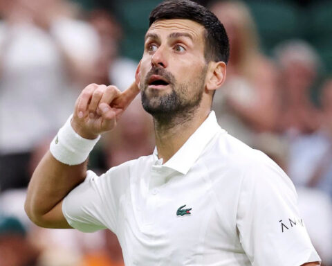 Serbian tennis star Novak Djokovic wearing a white tennis shirt during a match.