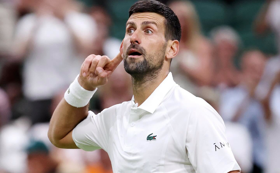 Serbian tennis star Novak Djokovic wearing a white tennis shirt during a match.