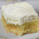 A slice of Yugoslavian apple cake with sponge cake, apple filling and whipped cream, served on a white plate.