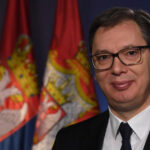 Aleksandar Vučić pictured in front of Serbian and European Union flags.