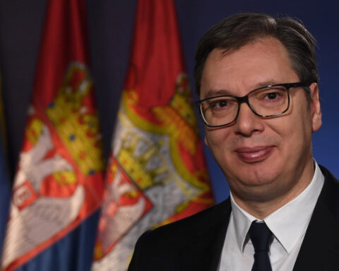Aleksandar Vučić pictured in front of Serbian and European Union flags.