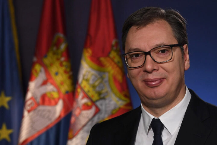 Aleksandar Vučić pictured in front of Serbian and European Union flags.