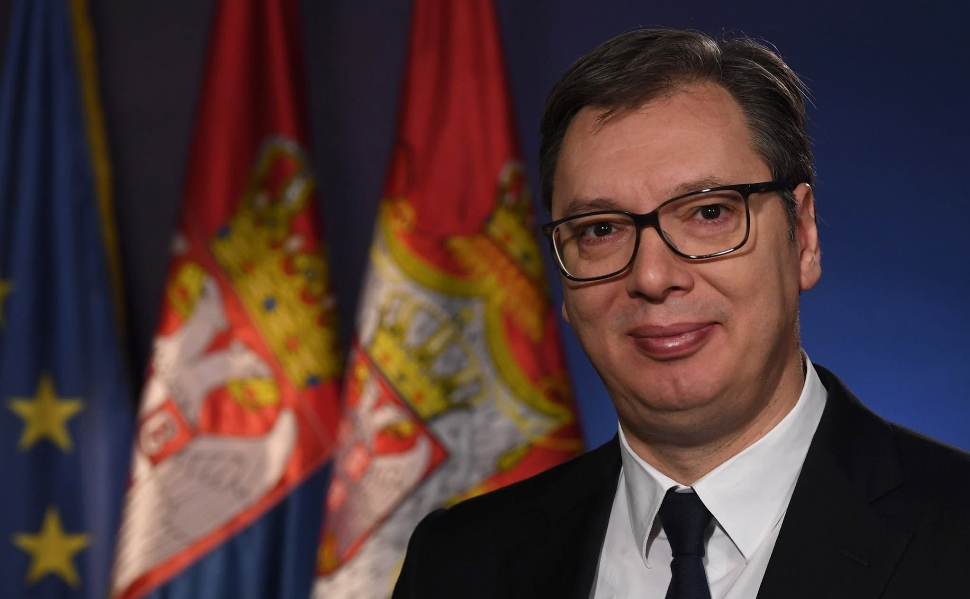 Aleksandar Vučić pictured in front of Serbian and European Union flags.