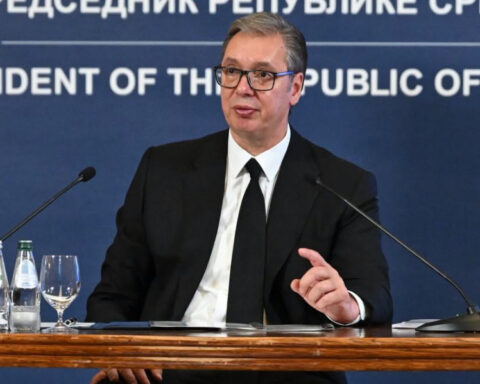 Aleksandar Vučić speaking at an official press conference in Serbia, seated behind microphones.