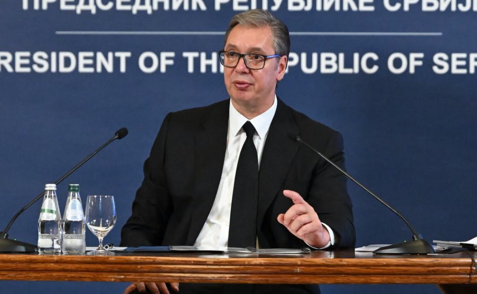 Aleksandar Vučić speaking at an official press conference in Serbia, seated behind microphones.