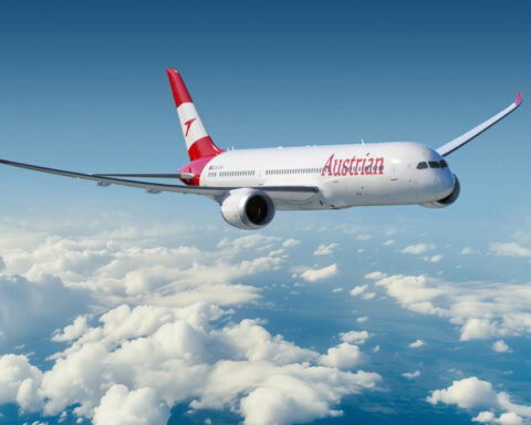 Austrian Airlines passenger aircraft flying above the clouds.