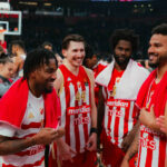 Crvena Zvezda basketball players celebrating together on the court after a EuroLeague game in Belgrade.