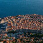 Aerial view of Dubrovnik's historic Old Town, medieval city walls, red rooftops and the Adriatic Sea in Croatia.