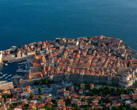 Aerial view of Dubrovnik's historic Old Town, medieval city walls, red rooftops and the Adriatic Sea in Croatia.
