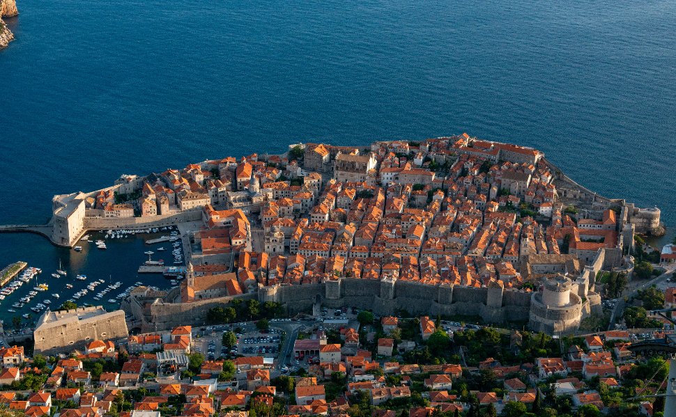 Aerial view of Dubrovnik's historic Old Town, medieval city walls, red rooftops and the Adriatic Sea in Croatia.