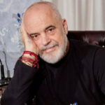 Albanian Prime Minister Edi Rama sitting in his office, resting his head on his hand.
