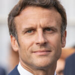 French President Emmanuel Macron wearing a navy blue suit and tie.