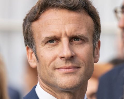 French President Emmanuel Macron wearing a navy blue suit and tie.