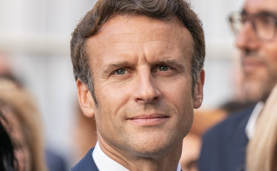 French President Emmanuel Macron wearing a navy blue suit and tie.
