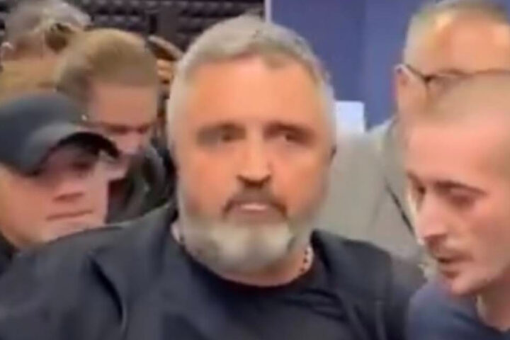 Dragan J. Vučićević surrounded by several people during a confrontation in Belgrade