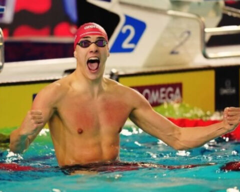 Croatian swimmer Jere Hribar celebrates in the swimming pool with his fists raised after a race.