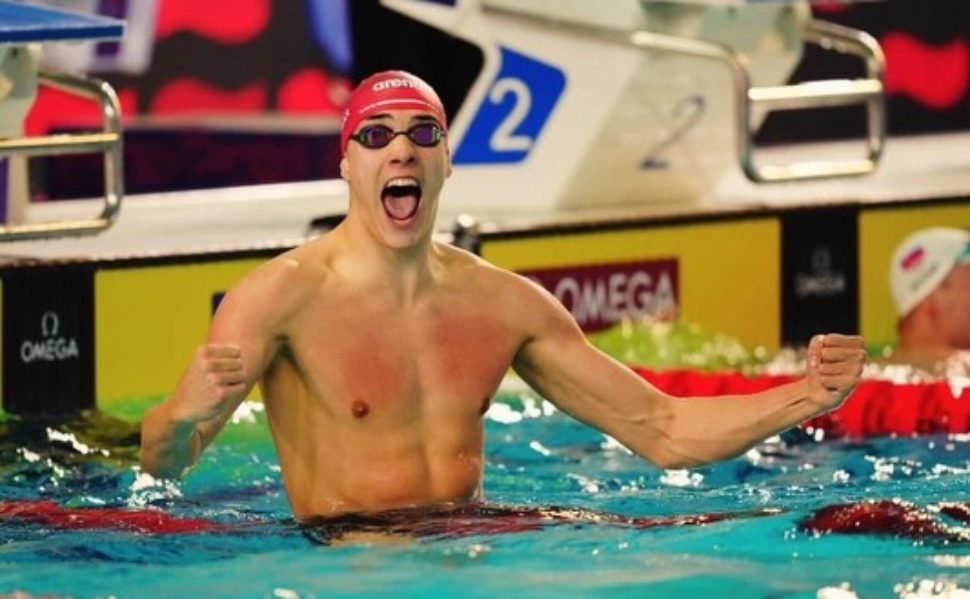 Croatian swimmer Jere Hribar celebrates in the swimming pool with his fists raised after a race.