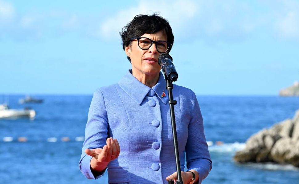 European Commissioner for Enlargement Marta Kos speaking at a podium with the European Union flag in the background.