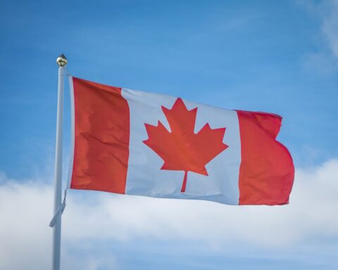 Canadian national flag waving against a blue sky, illustrating the Alberta separation referendum and Canada's national unity.