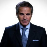 IAEA Director General Rafael Grossi wearing a dark suit and blue tie against a white background.