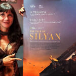 Macedonian filmmaker Tamara Kotevska poses next to a promotional poster for her documentary The Tale of Silyan.