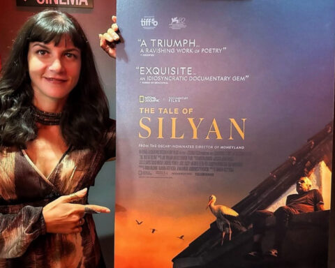 Macedonian filmmaker Tamara Kotevska poses next to a promotional poster for her documentary The Tale of Silyan.