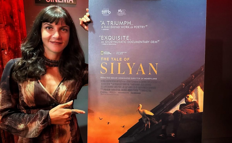 Macedonian filmmaker Tamara Kotevska poses next to a promotional poster for her documentary The Tale of Silyan.