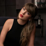 Taylor Swift wearing a black sleeveless dress in an official portrait shared on her Facebook page.
