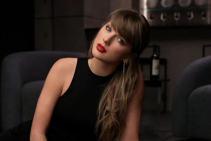 Taylor Swift wearing a black sleeveless dress in an official portrait shared on her Facebook page.