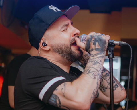Vladimir Blažev Pancho, member of Macedonian music duo DNK, singing into a microphone during a live performance.